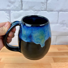 Load image into Gallery viewer, Aurora Borealis Mugs. each one is different. northwest style coffee mug thrown Red Stoneware, with large pulled handle. black glaze base with swirls of blue, turuoise, and hints of purple, reminiscent of the Aurora Borealis.
