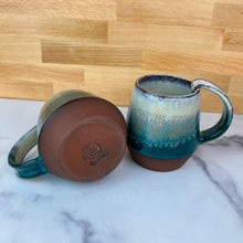 Load image into Gallery viewer, Forest Mist Mugs by Meredith from Fern Street Pottery. This image shows the flat finished bottom of the mugs. white, teal, mist, stoneware.
