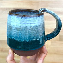 Load image into Gallery viewer, A handmade ceramic mug with a pulled handle, featuring a glaze that transitions from speckled white at the top to a deep teal over a deep red-brown stoneware clay. Forest Mist Mug
