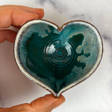 Load image into Gallery viewer, A handmade heart-shaped ceramic bowl with a glossy teal and White dripping glaze, held by a hand against a white marble background.