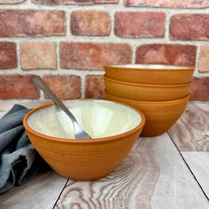set of four stacking bowls, perfect size for soup, cereal, salad, or ice cream. These bowls are glazed with a speckled, rustic white glaze inside and feature the red-brown exposed stoneware clay on the exterior.