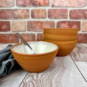 set of four stacking bowls, perfect size for soup, cereal, salad, or ice cream. These bowls are glazed with a Glossy, speckled, white glaze inside and feature the red-brown exposed stoneware clay on the exterior.