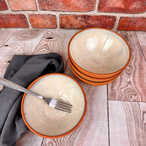 Set of four stacking bowls. Red stoneware clay, glazed speckled white on the inside with the outside left unglazed, showing  the clay surface.