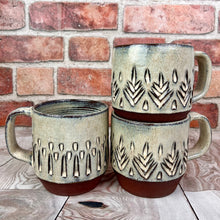 Load image into Gallery viewer, stacked mugs, hand carved and made by artist Meredith Chernick. stackable and dishwasher safe.