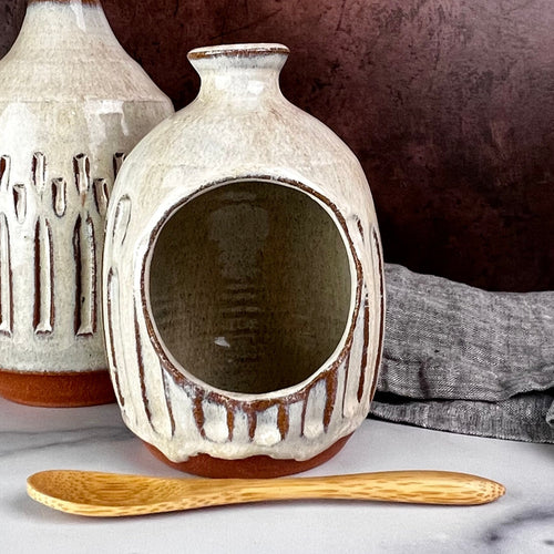 Salt Cellar, also known as a salt well or salt pig. shown here with matching Olive oil cruet. Wheel thrown and carved. comes with a bamboo spoon and a starter sea salt packet.. Thrown in a red stoneware clay, with a handled top, and carved by hand. the white glaze accentuates the carved pattern where the red clay shows through. Fern Street Pottery