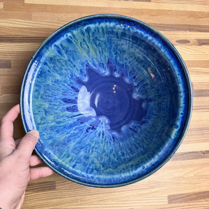 Large, wheel thrown serving bowl. Thrown in a deep red stoneware and glazed in "Blue World" which is layers of blues and turquoise, running together