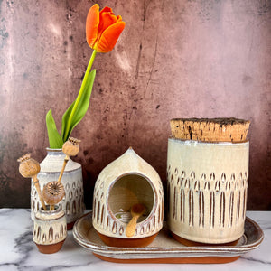 Canister (Medium size) for beautiful display and storage. this canister is wheel thrown from red stoneware clay, carved with a pattern and glazed in a speckled white glaze. the canister has a natural, rough cork lid. shown here with a mini bud vases, salt cellar and tray, sold separately.