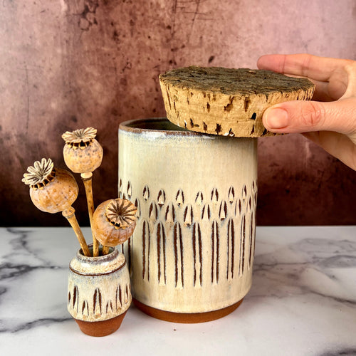 Canister (Medium size) for beautiful display and storage. this canister is wheel thrown from red stoneware clay, carved with a pattern and glazed in a speckled white glaze. the canister has a natural, rough cork lid. shown here with a mini bud vase, sold separately.