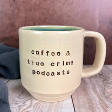 Load image into Gallery viewer, A true crime lovers favorite mug!hand crafted, wheelthrown mug with &quot;coffee &amp; true crime podcasts&quot; stamped into the face of the mug. glazed with a glossy turquoise interior.