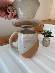 Detail shot of bottom of Coffee pour over and drip edge. wheel-thrown pottery, white glaze with speckled white glaze. shown with matching angle dipped mug and carved bud vase. Fern Street Pottery