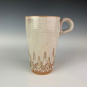 Tree carved travel mug. red stoneware, white glaze, hand carved tree pattern. no lid