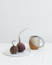 Load image into Gallery viewer, Fern Street Pottery. Angle dipped mug. Large Pottery Mug in speckled white, angle dipped glaze. wheel thrown with pulled handle. shown in contemporary setting with vegetables