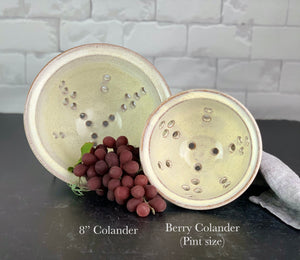 an 8"diameter colander and a pint sized Berry colander in speckled white glaze