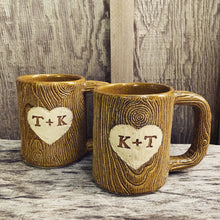 Load image into Gallery viewer, Large custom coffee mugs with lumberjack, woodgrain pattern impressed and carved in for texture you can feel. the mugs have a heart carved into them with initials, like lovers would carve into a tree